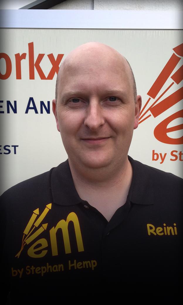 Mann mit schwarzem Shirt vor Werbetafel